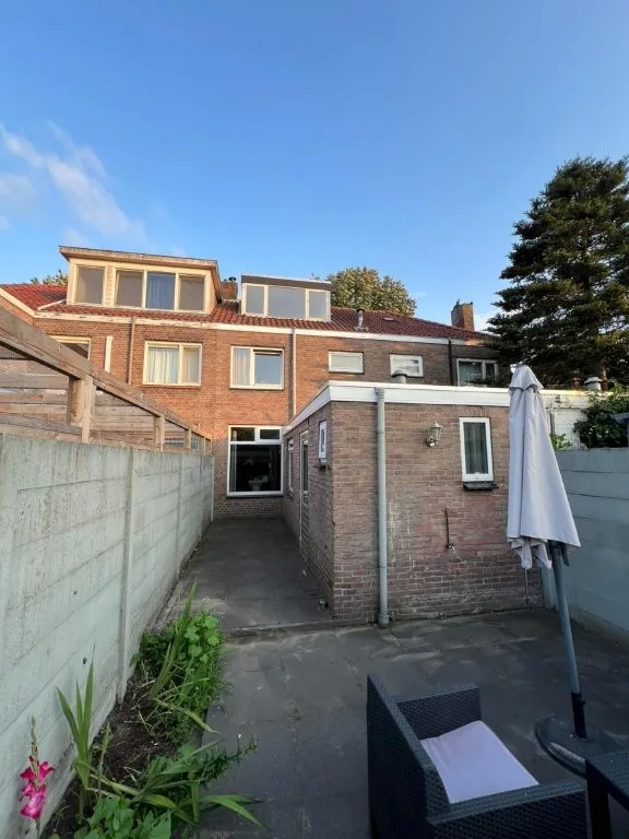 Achtergevel met aanbouw en tuin