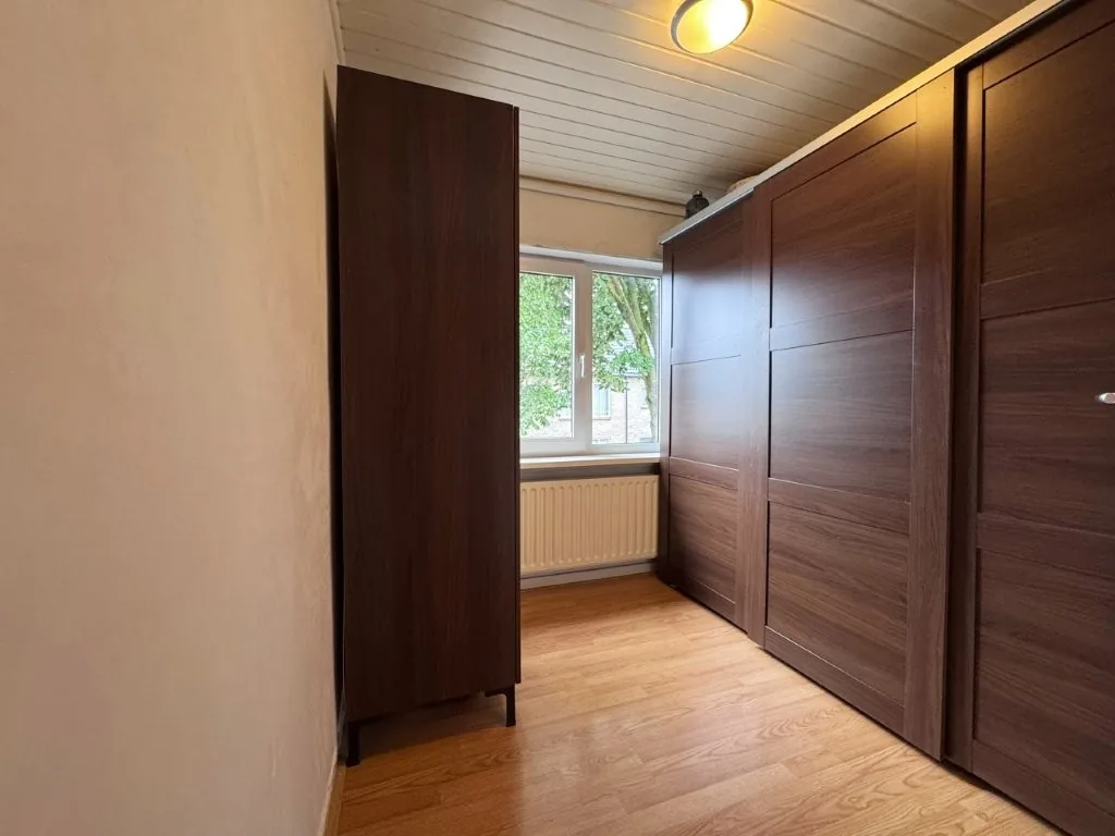 Slaapkamer met donkerhouten kastenwand